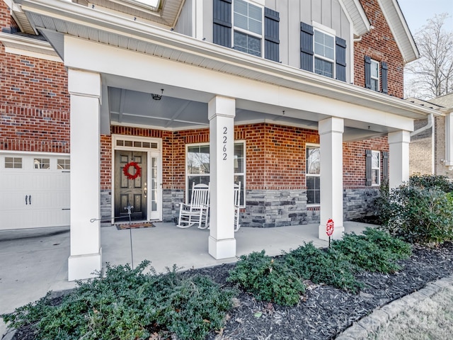 view of exterior entry featuring covered porch and a garage