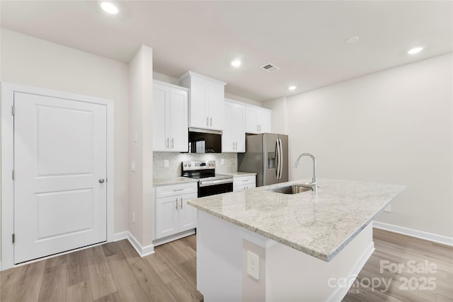 kitchen featuring sink, white cabinets, stainless steel appliances, and a kitchen island with sink