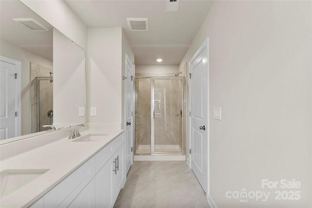 bathroom featuring vanity, walk in shower, and tile patterned flooring