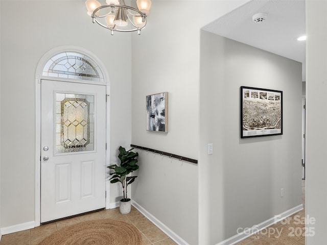 tiled entrance foyer with a notable chandelier