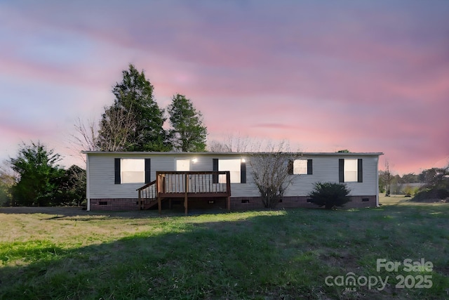 manufactured / mobile home with a lawn and a wooden deck