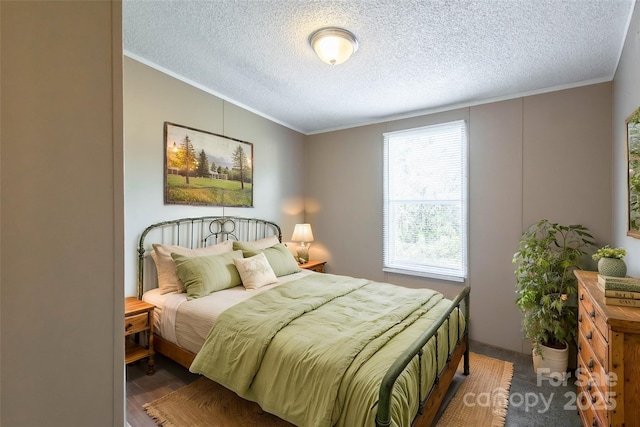 bedroom featuring wood-type flooring, a textured ceiling, and ornamental molding