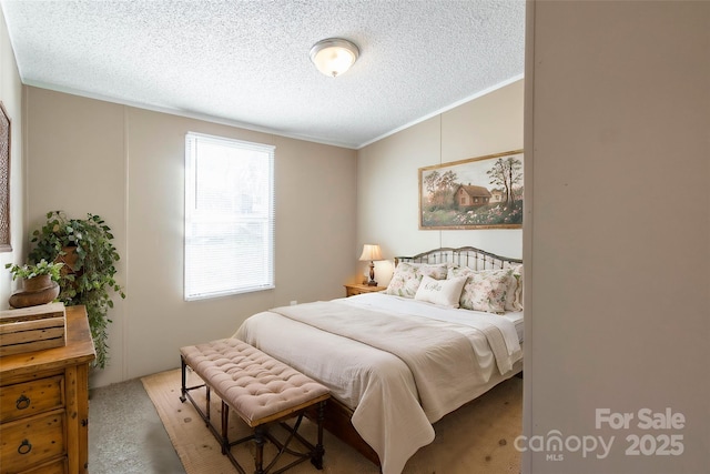 carpeted bedroom featuring ornamental molding and a textured ceiling