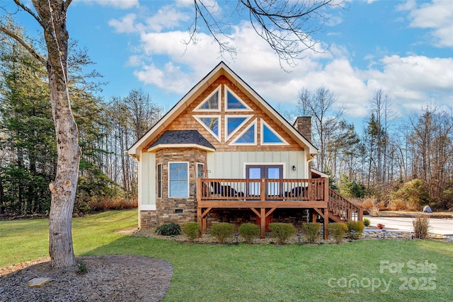 view of front of home with french doors, a front lawn, and a deck