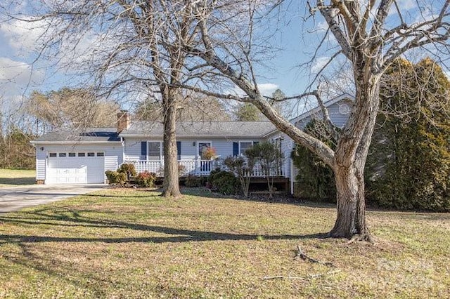 view of front of property with covered porch, a garage, and a front yard