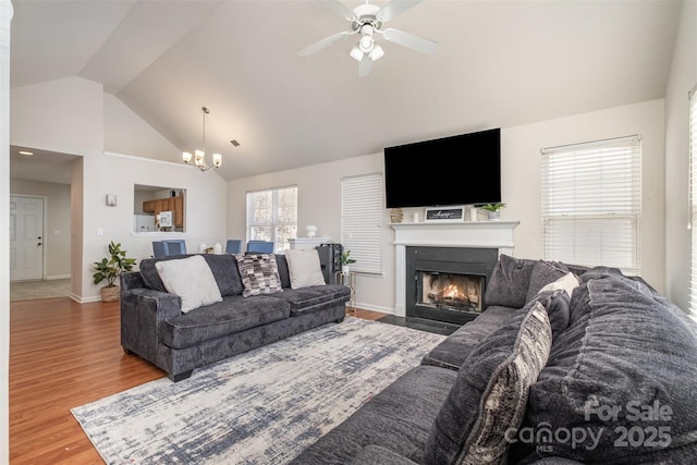 living room featuring ceiling fan with notable chandelier, high vaulted ceiling, and wood-type flooring