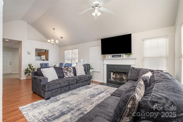 living room featuring lofted ceiling, hardwood / wood-style floors, and ceiling fan with notable chandelier