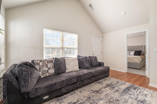 living room featuring light wood-type flooring and high vaulted ceiling