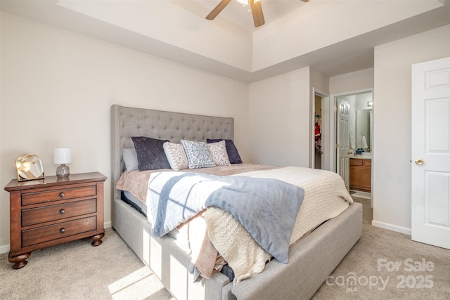 bedroom featuring ceiling fan, ensuite bath, and light colored carpet