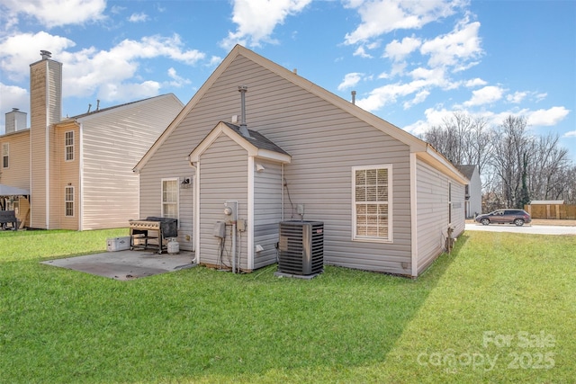 back of house with a patio area, a lawn, and central air condition unit