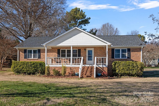 ranch-style home with covered porch and a front yard