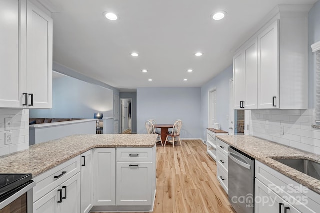 kitchen with white cabinets, decorative backsplash, stainless steel dishwasher, and light stone countertops