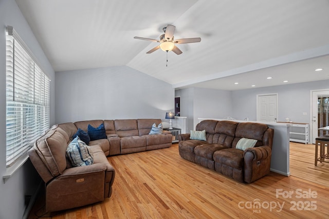 living room featuring light hardwood / wood-style floors, ceiling fan, and lofted ceiling