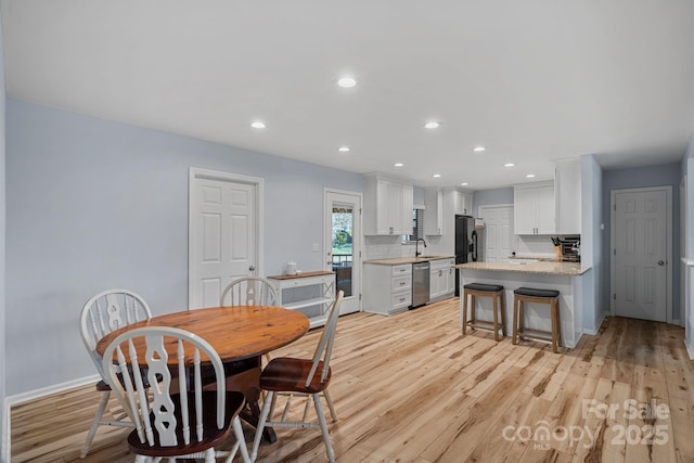 dining room with sink and light hardwood / wood-style flooring