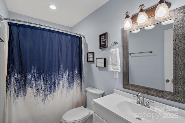 bathroom with a shower with shower curtain, vanity, and toilet