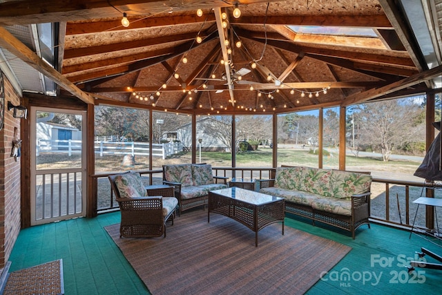 unfurnished sunroom with vaulted ceiling with skylight