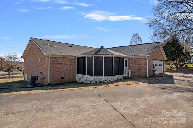 rear view of property featuring central AC, a sunroom, and a garage