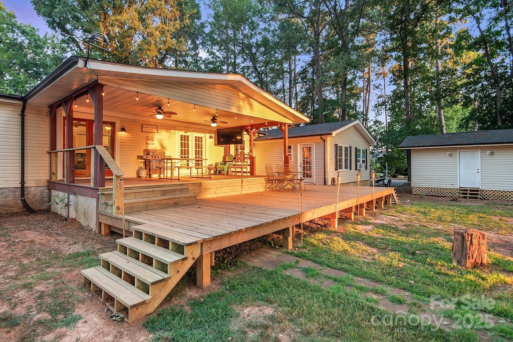 wooden terrace with ceiling fan and a storage unit