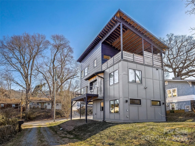 rear view of house featuring a yard and a balcony