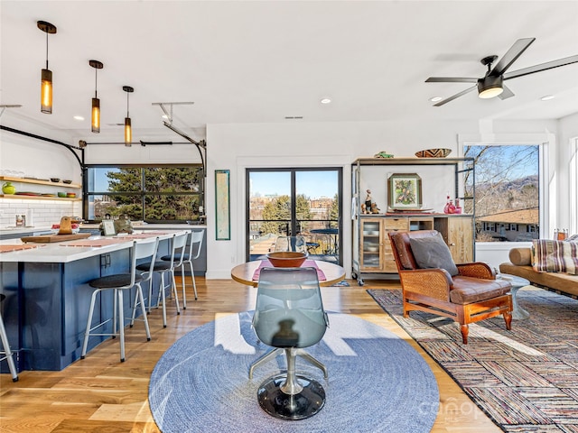 living room featuring ceiling fan and light hardwood / wood-style floors