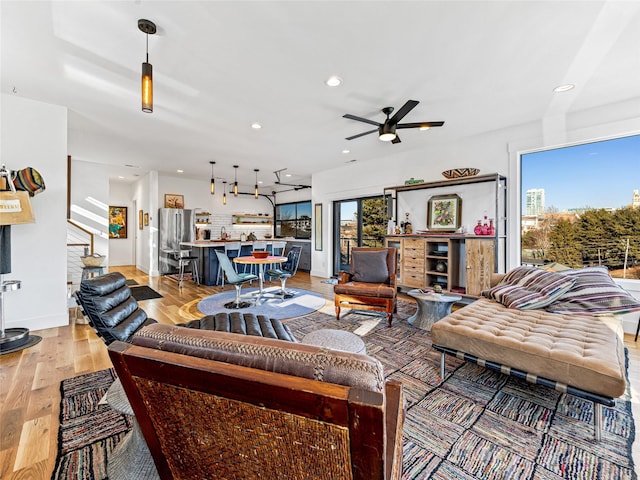 living room featuring ceiling fan and light wood-type flooring