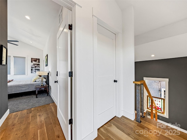 hall featuring light hardwood / wood-style flooring and lofted ceiling