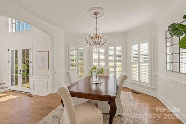 dining area with crown molding, a chandelier, and a healthy amount of sunlight