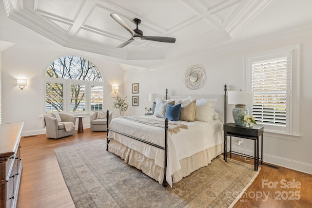 bedroom featuring ceiling fan, light hardwood / wood-style flooring, coffered ceiling, and multiple windows