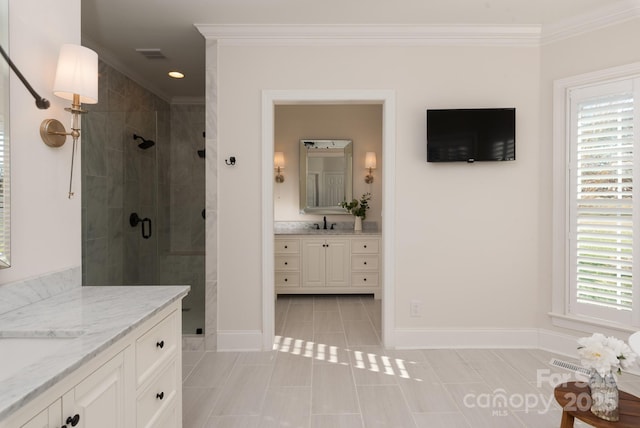 bathroom featuring a wealth of natural light, vanity, crown molding, and tile patterned flooring