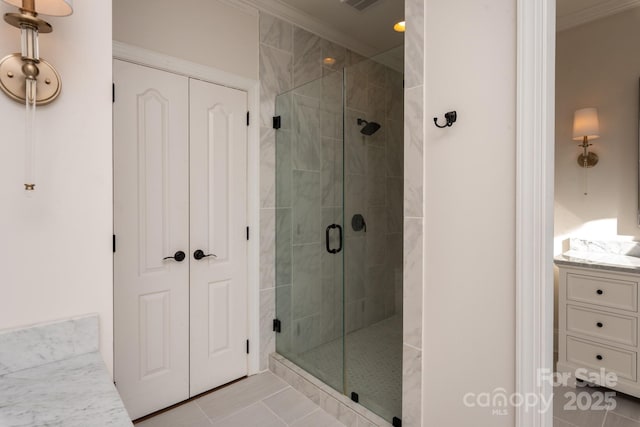 bathroom with a shower with shower door, crown molding, and tile patterned flooring