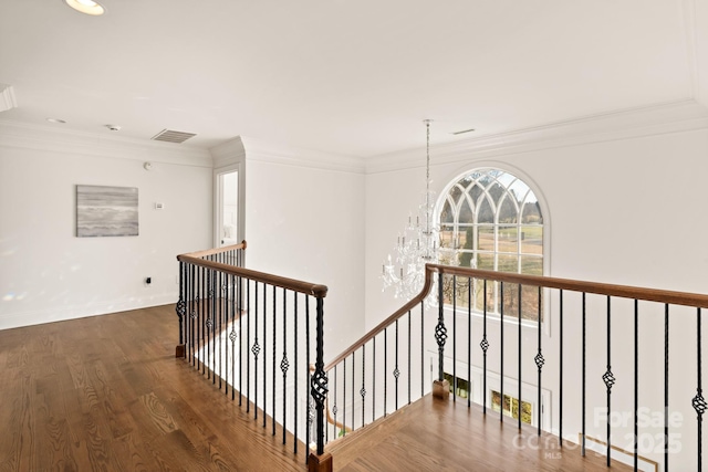 hallway featuring an inviting chandelier, crown molding, and dark hardwood / wood-style floors