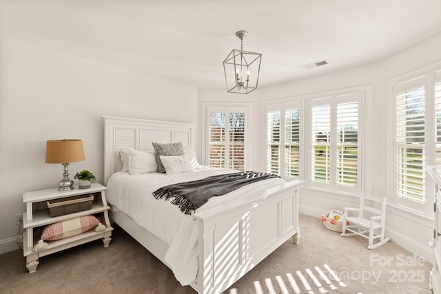 bedroom with light carpet and a chandelier