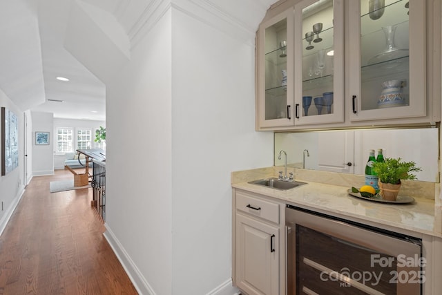 bar featuring dark wood-type flooring, sink, light stone countertops, and wine cooler