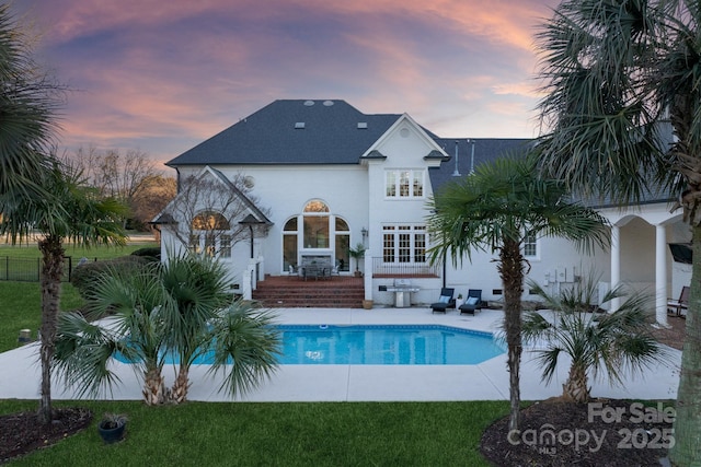 pool at dusk featuring a patio