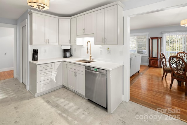 kitchen featuring dishwasher, sink, white cabinets, and light wood-type flooring