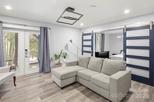 living room featuring light hardwood / wood-style flooring and a barn door