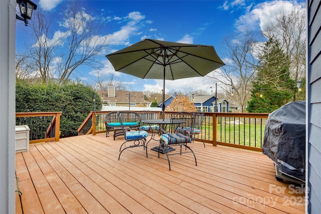 wooden terrace featuring a grill and a yard