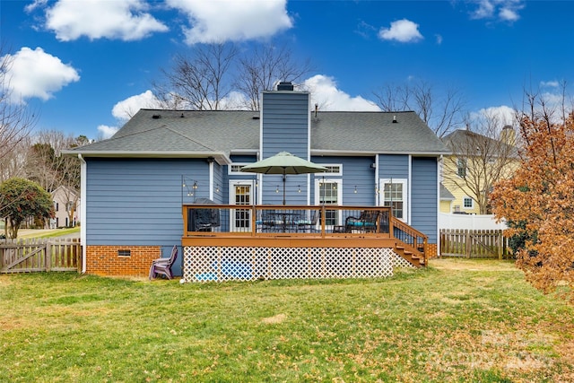 rear view of house featuring a lawn and a deck