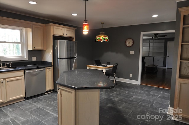 kitchen featuring stainless steel appliances, ceiling fan, sink, pendant lighting, and a center island