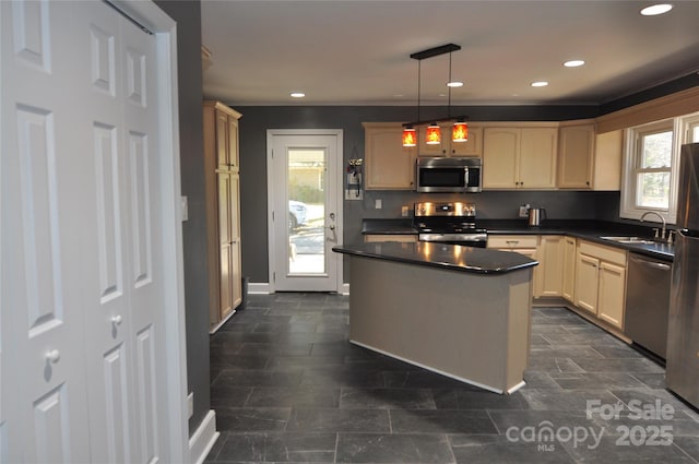 kitchen featuring cream cabinets, sink, stainless steel appliances, and decorative light fixtures