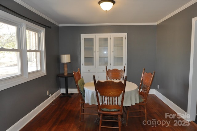 dining area with dark hardwood / wood-style floors and crown molding