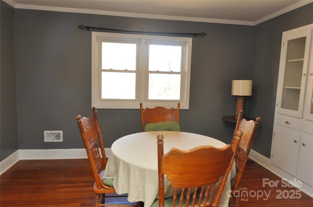 dining room featuring dark hardwood / wood-style floors and ornamental molding