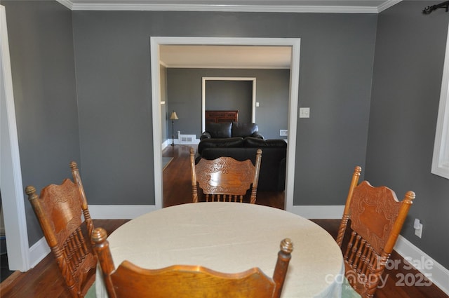 dining area with crown molding and dark wood-type flooring