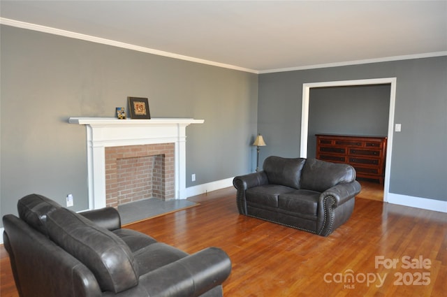 living room with hardwood / wood-style flooring, ornamental molding, and a brick fireplace