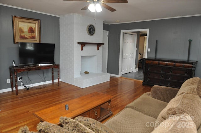 living room with a fireplace, hardwood / wood-style flooring, ceiling fan, and ornamental molding