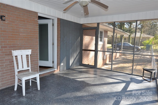 unfurnished sunroom featuring ceiling fan