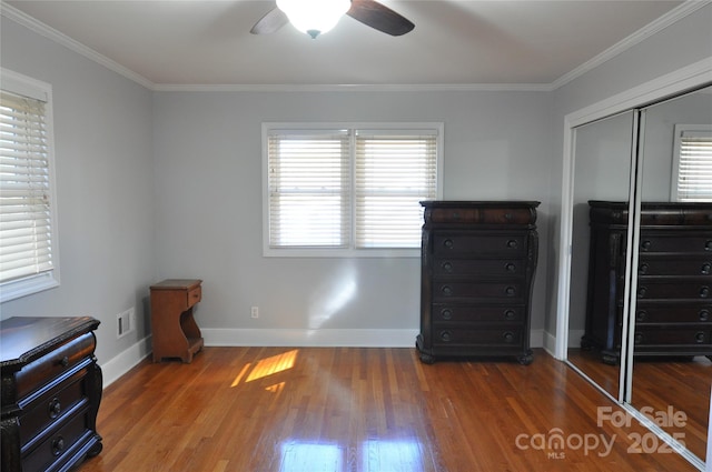 unfurnished bedroom with wood-type flooring, a closet, ceiling fan, and ornamental molding