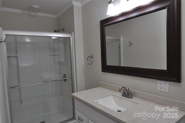 bathroom with vanity, a shower with shower door, and crown molding