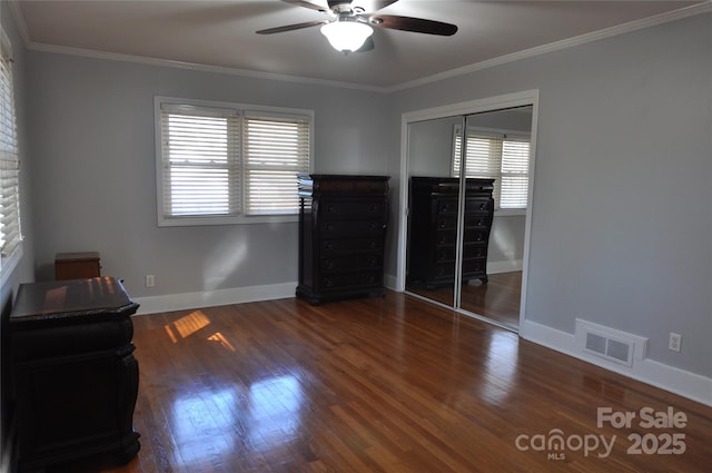 interior space with ceiling fan, ornamental molding, dark wood-type flooring, and a closet