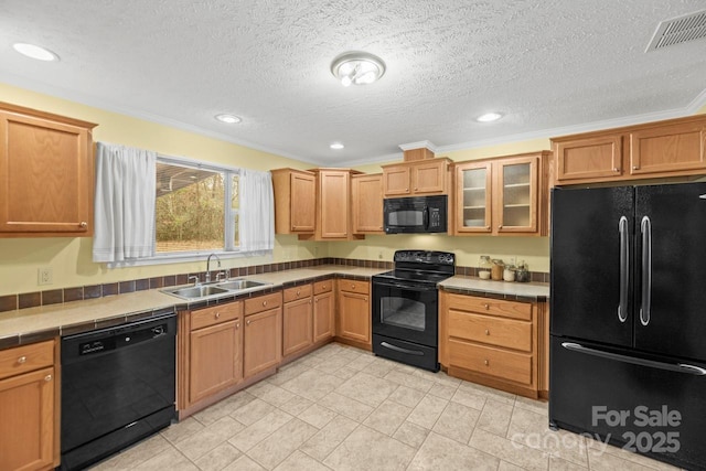 kitchen featuring sink, tile countertops, a textured ceiling, ornamental molding, and black appliances